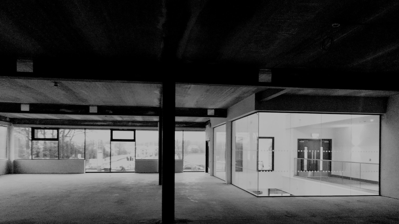 Reduziertes modernes Interieur mit Sichtbeton, Glas und geometrischen Übergängen